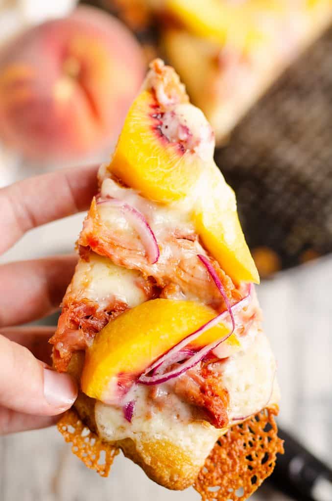 slice of BBQ Peach Pizza held in hand