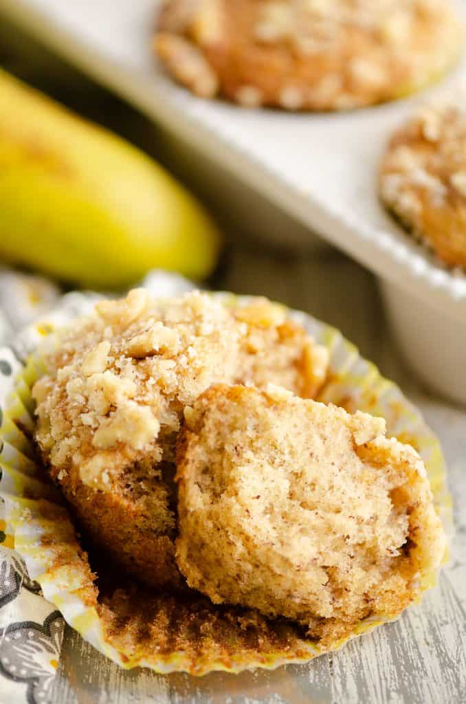 Banana Nut Muffin with Streusel Topping broke in half in yellow liner