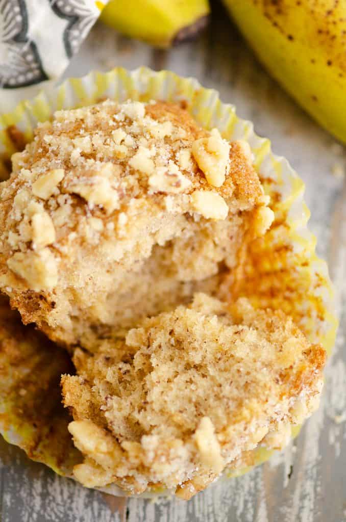 Banana Nut Muffin with Streusel Topping broke in half in yellow liner