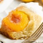 slice of Peach Upside Down Cake on white scalloped plate with fork
