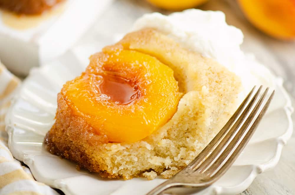 slice of Peach Upside Down Cake on white scalloped plate with fork