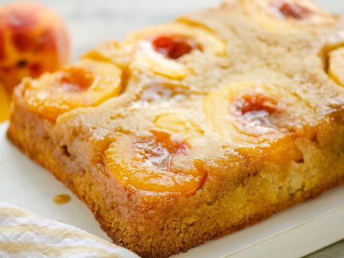 Peach Upside Down Cake on table with fresh peaches