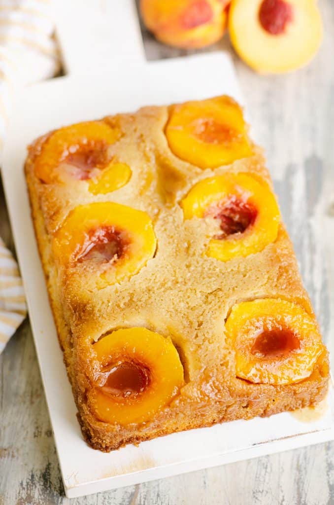 Peach Upside Down Cake on table with dish cloth