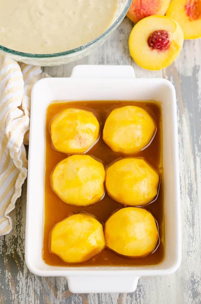 fresh peach halves in baking pan with brown sugar and butter