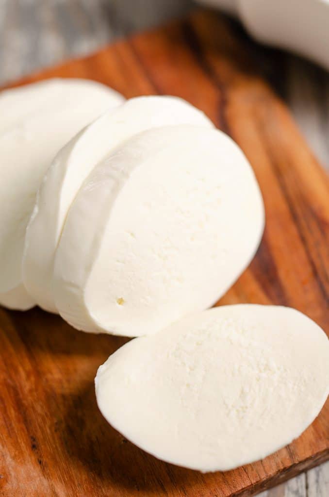 Fresh mozzarella sliced on cutting board