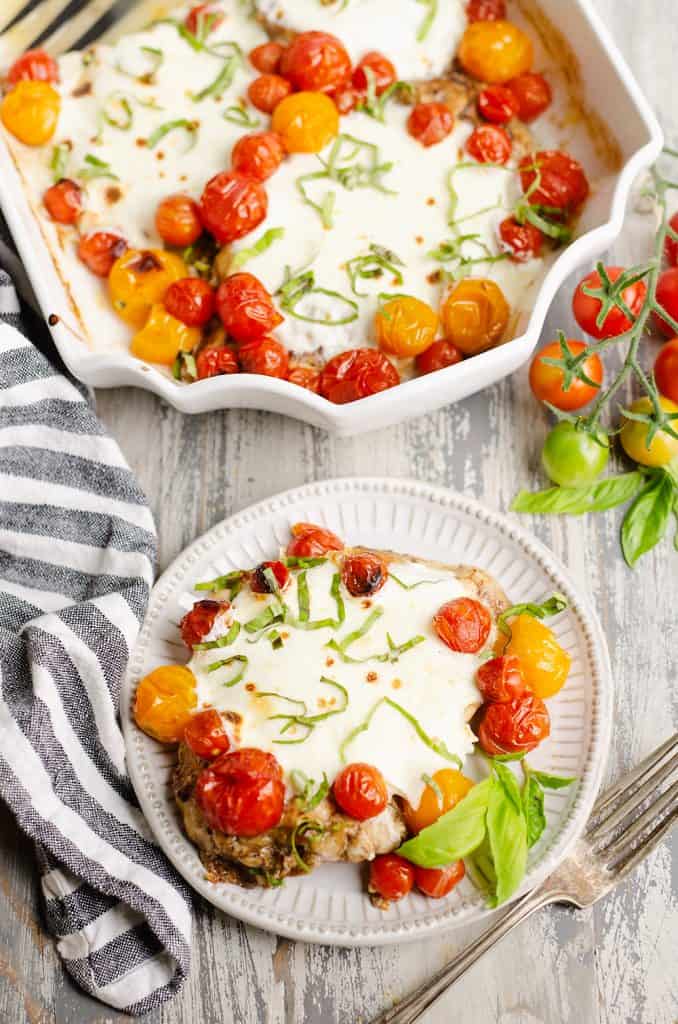 Honey Balsamic Caprese Chicken on plate and in baking dish on white wash table