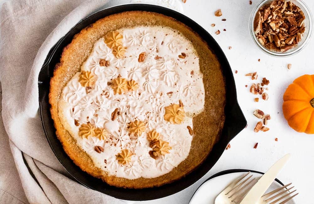 Pumpkin Spicy Dutch Baby on white table with pumpkin and pecans