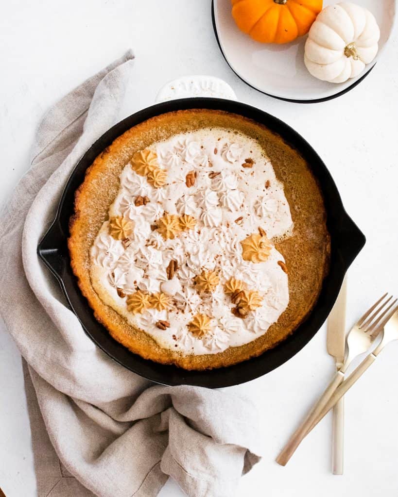 Pumpkin Spicy Dutch Baby on white table with small pumpkins