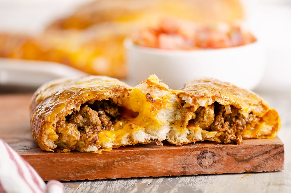 Air Fryer Taco Calzones broken in half on cutting board