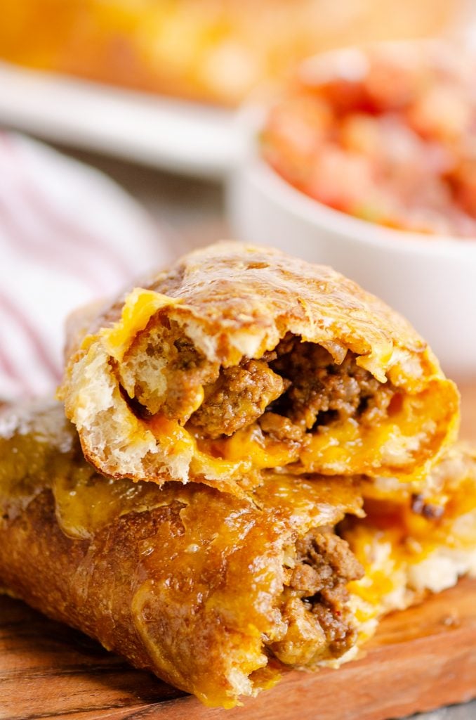 Air Fryer Taco Calzones broken in half stacked on cutting board