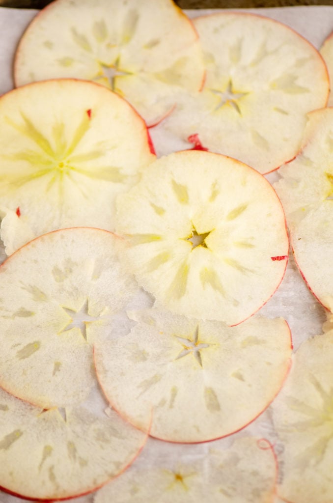 thinly sliced apples on parchment