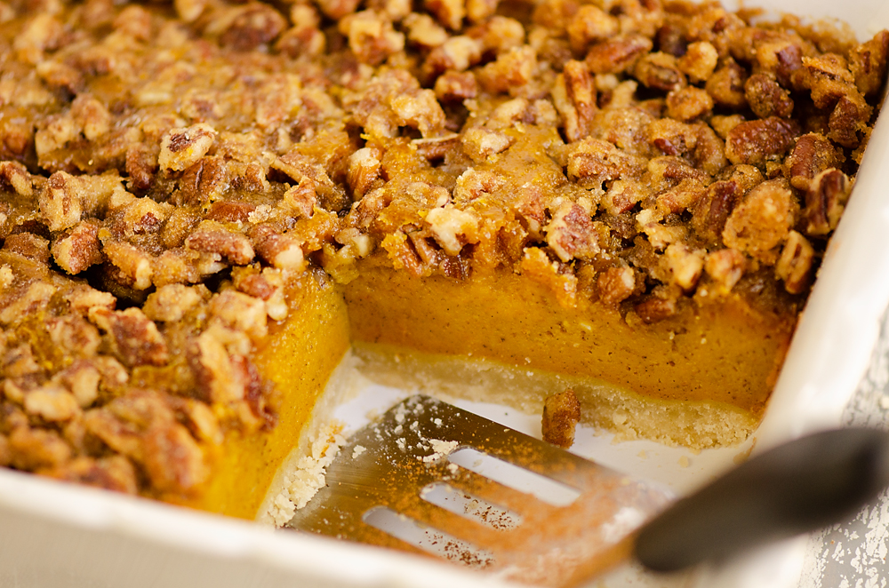 Pumpkin Pecan Custard Pie Bars in pan with spatula