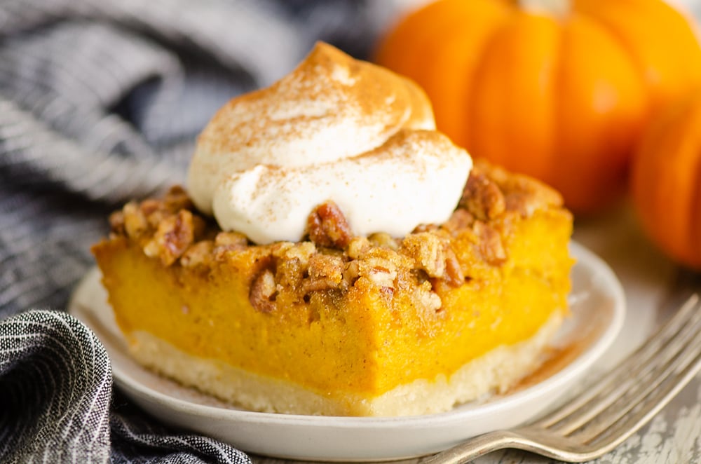 Pumpkin Pecan Custard Pie Bars on plate with whipped cream