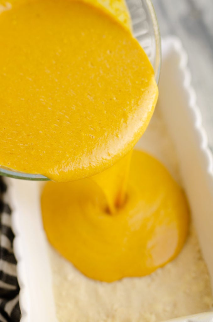 pumpkin custard poured onto pie crust in bar pan