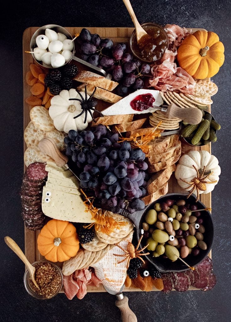 Halloween Charcuterie Board with spiders and pumpkins on cutting board