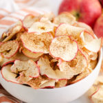 baked apple chips in bowl with apples