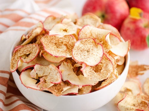 baked apple chips in bowl with apples