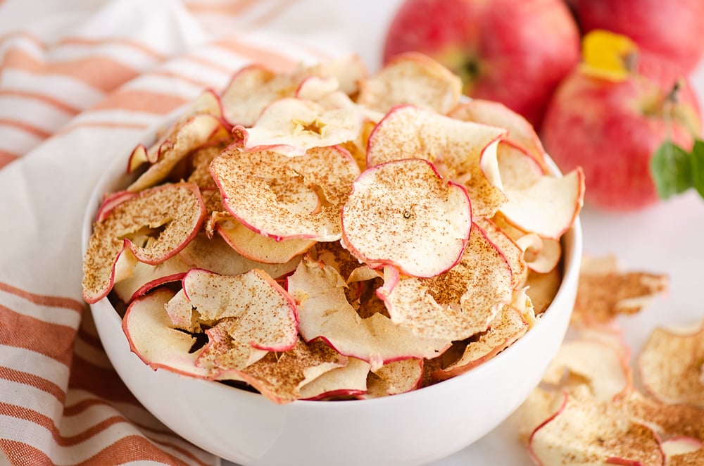 baked apple chips in bowl with apples