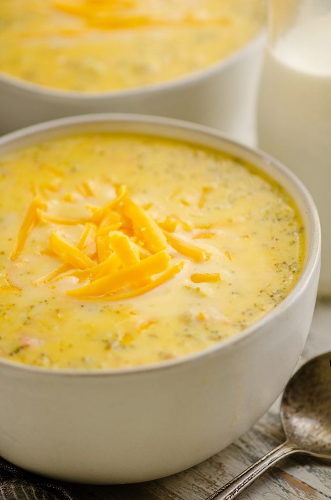 Pressure Cooker Cheesy Ham & Broccoli Soup in white bowl with glass jar of milk