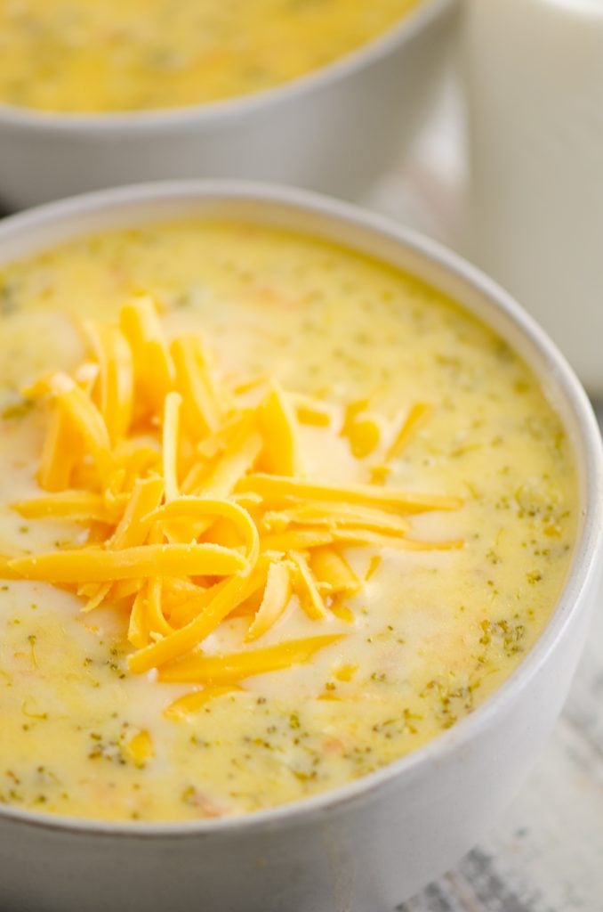 Pressure Cooker Cheesy Ham & Broccoli Soup in white bowl with cheddar cheese