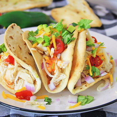 Pressure Cooker Chili Lime Chicken Tacos topped with cheese and vegetables