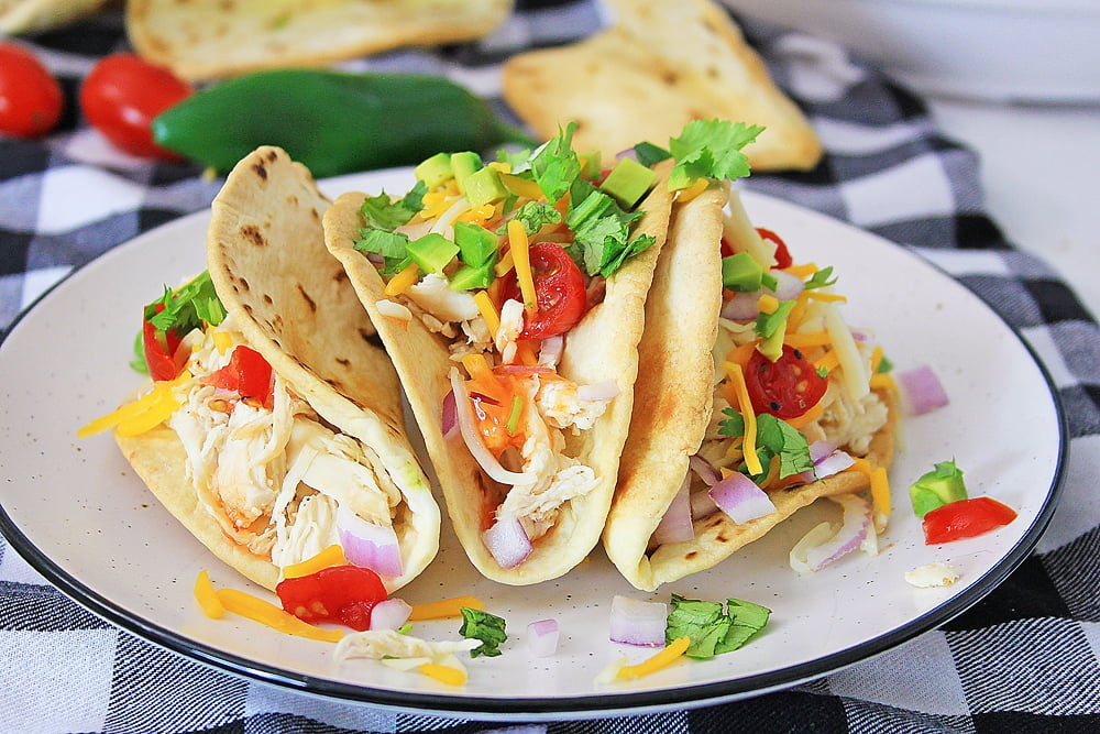 Pressure Cooker Chili Lime Chicken Tacos topped with cheese and vegetables