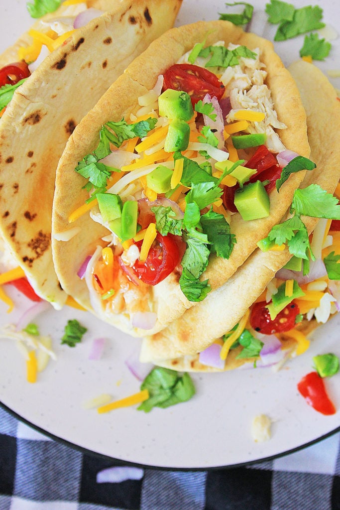 Pressure Cooker Chili Lime Chicken Tacos topped with tomatoes cheese and cilantro