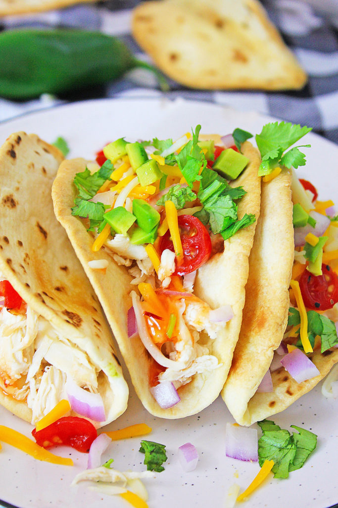 Pressure Cooker Chili Lime Chicken Tacos on white plate topped with cilantro