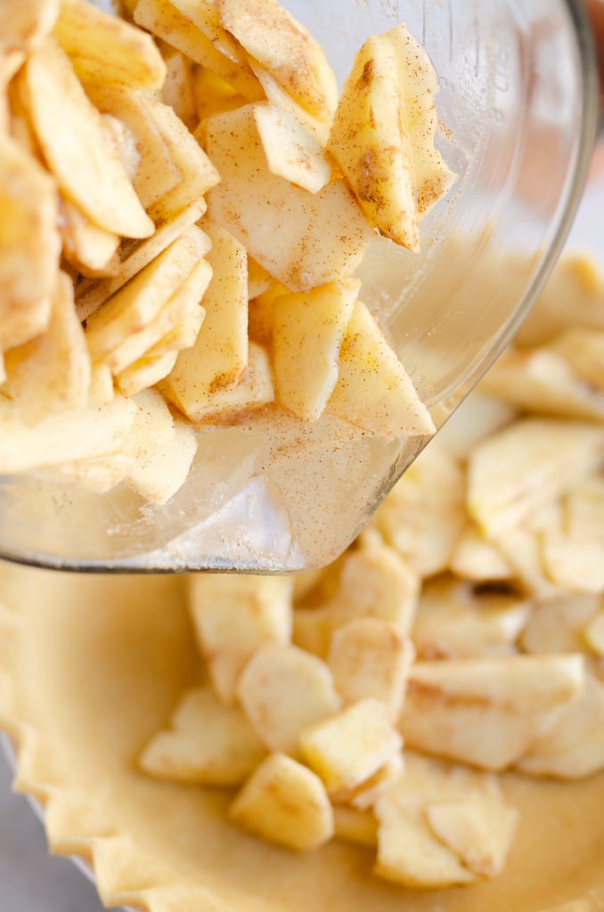 spiced apples added to flaky pie crust