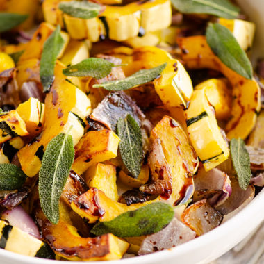 Crispy Sage Roasted Delicata Squash with balsamic glaze in white bowl