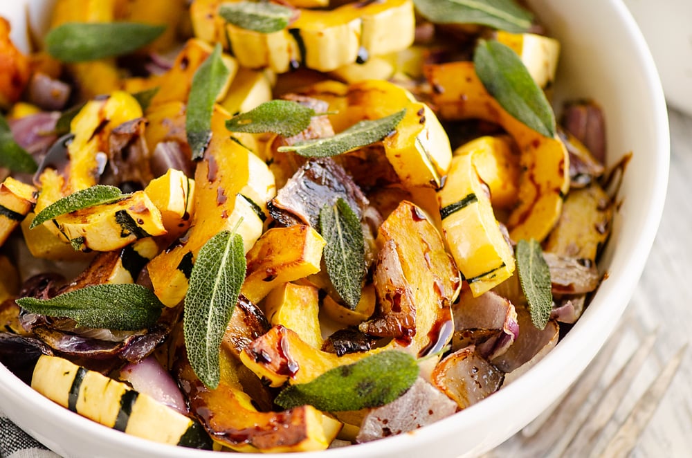 Crispy Sage Roasted Delicata Squash with balsamic glaze in white bowl