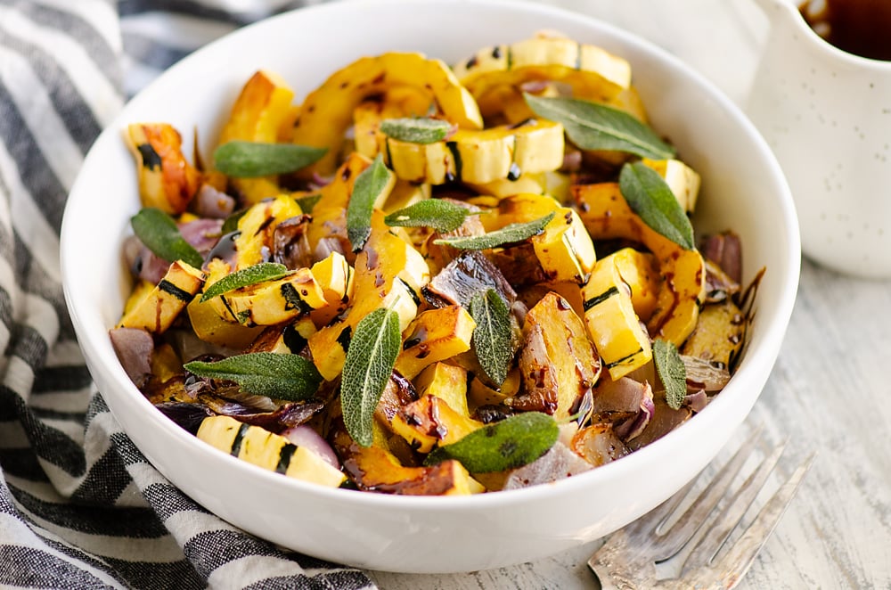 Crispy Sage Roasted Delicata Squash with balsamic glaze in white bowl