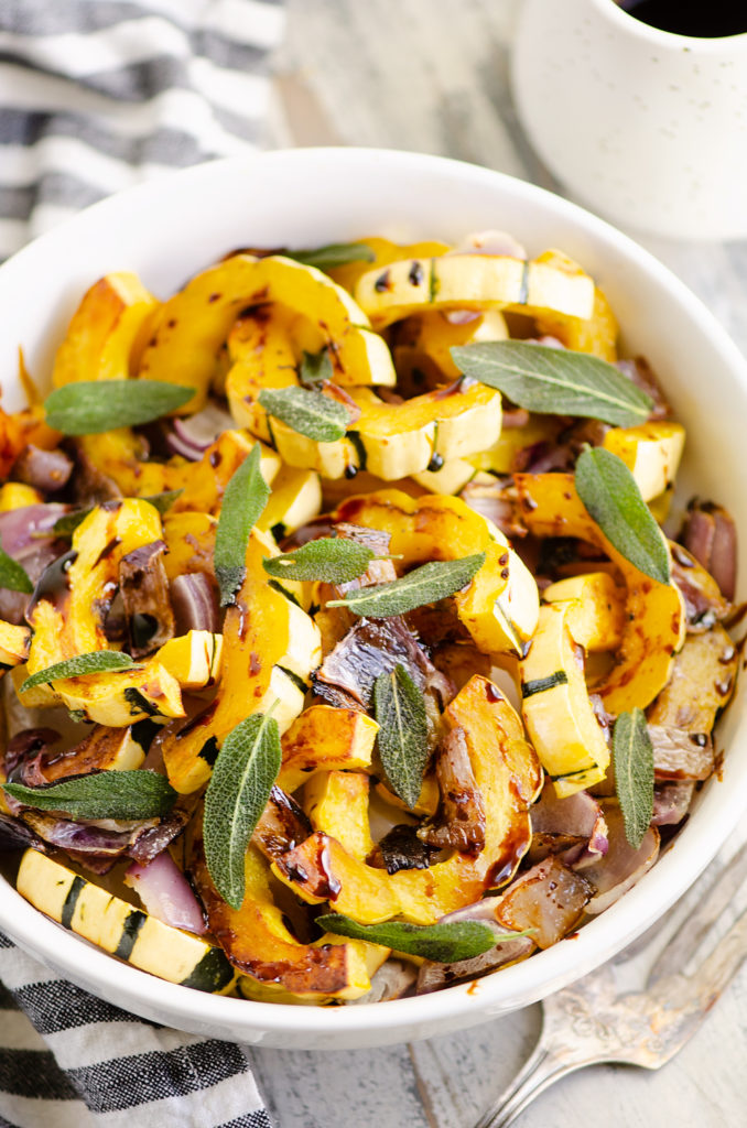 Crispy Sage Roasted Delicata Squash with balsamic glaze in white bowl