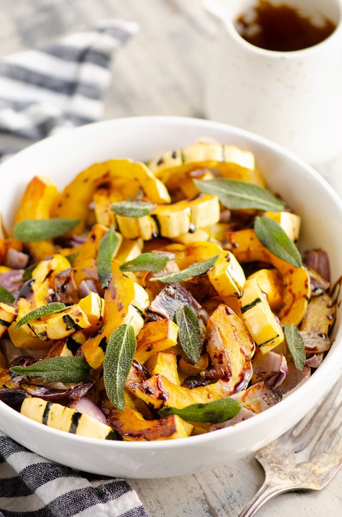 Crispy Sage Roasted Delicata Squash with balsamic glaze in white bowl