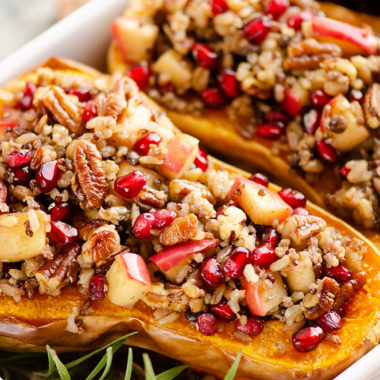 Stuffed Butternut Squash with Apples, Pomegranates & Grains in white baking pan with rosemary