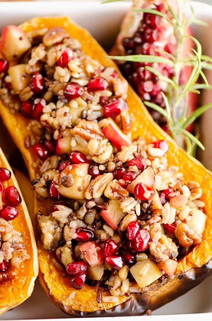 Stuffed Butternut Squash with Apples, Pomegranates & Grains with pomegranate piece and rosemary