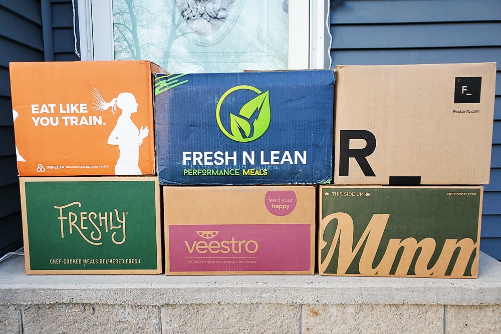 prepared meal delivery boxes stacked on front step