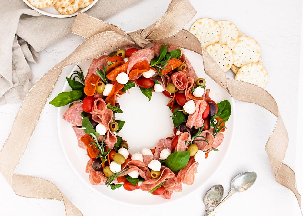 Christmas antipasto wreath on white plate with ribbon