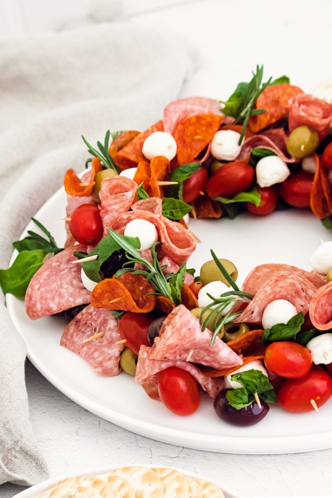 antipasto wreath made from skewers of meat and cheese on white plate