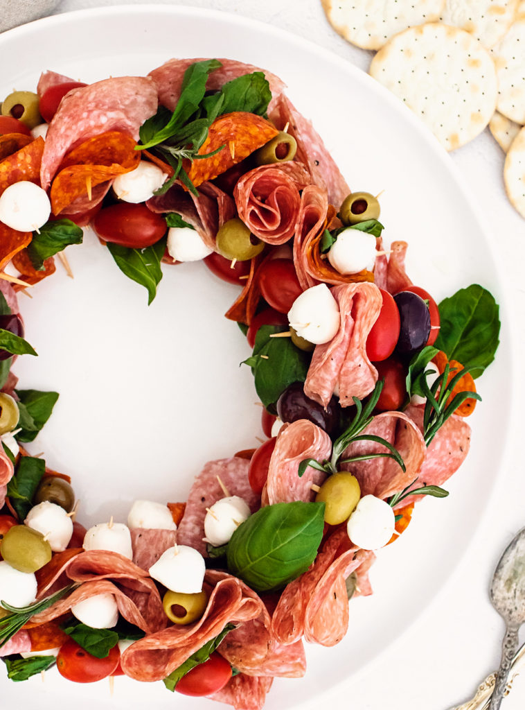 christmas antipasto wreat on white plate served with crackers