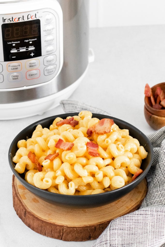 bowl of Bacon Mac and Cheese on table with Instant Pot