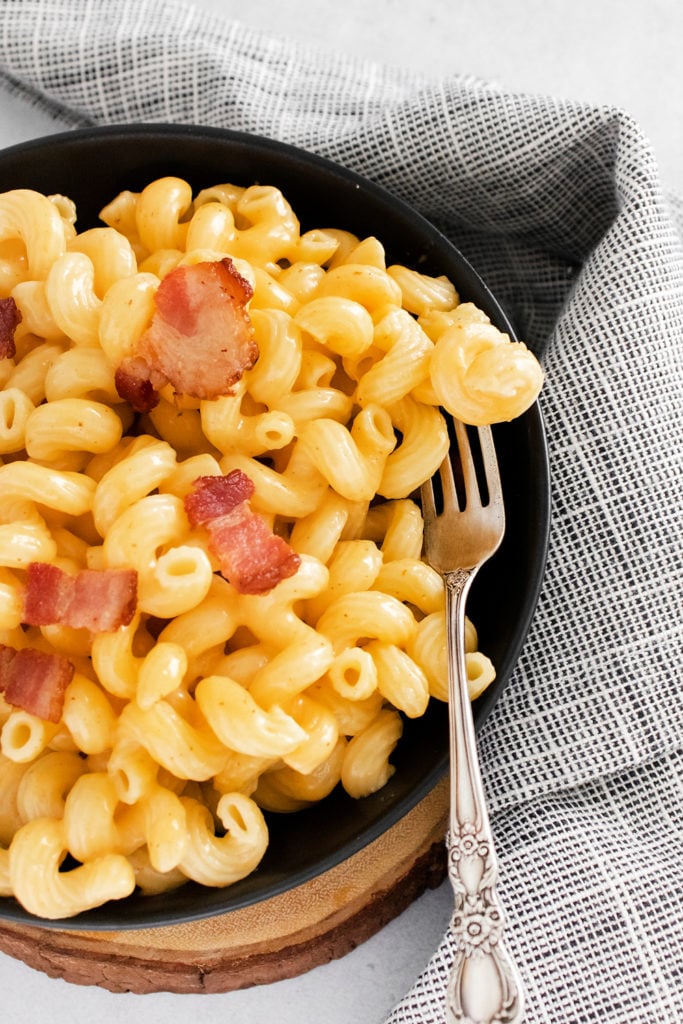 Pressure Cooker Bacon Mac and Cheese in black bowl with fork
