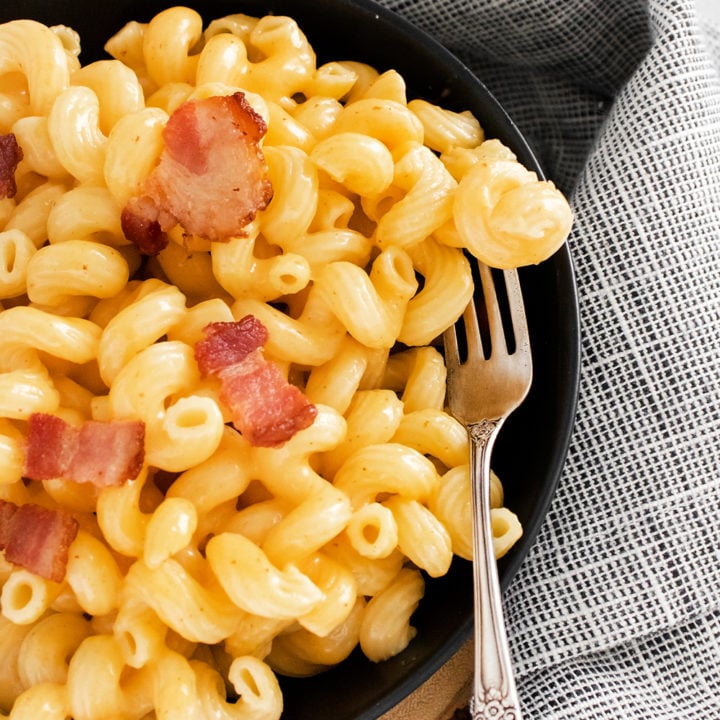 Pressure Cooker Bacon Mac and Cheese in black bowl with fork