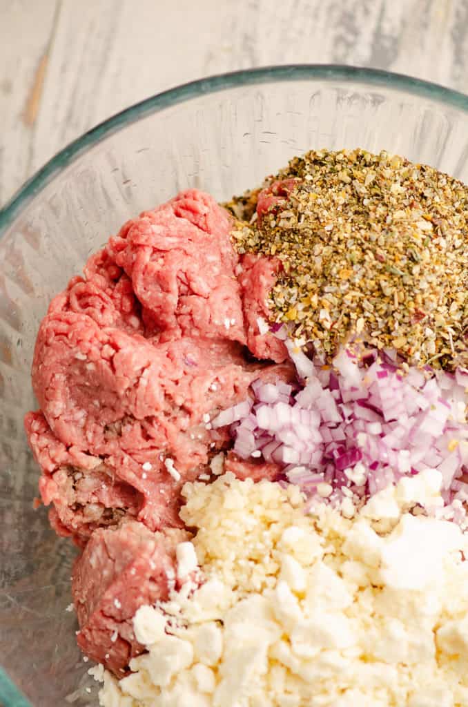 Glass bowl with ground beef, Greek Freak, red onion and feta cheese