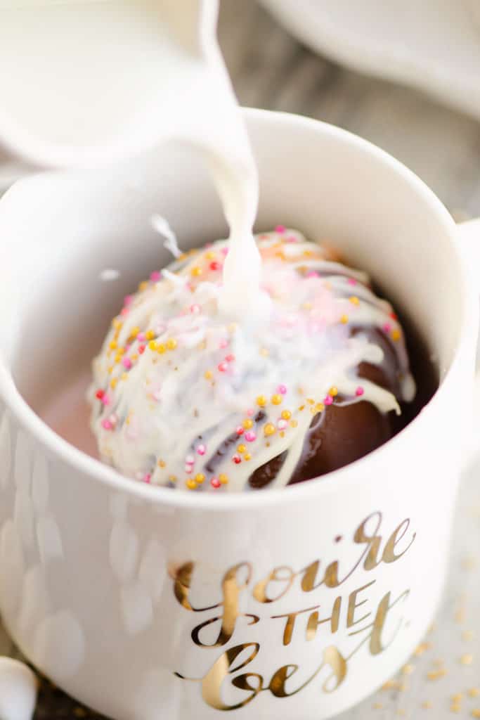 hot cocoa bomb in mug with hot milk poured over it