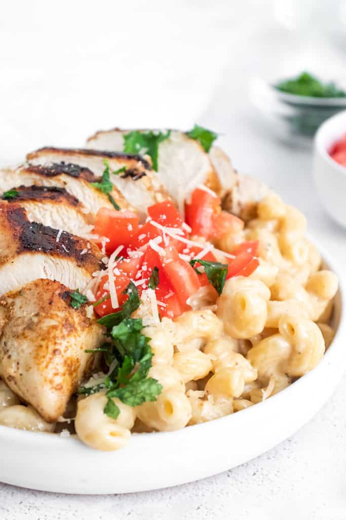 cajun chicken breasts sliced over alfredo pasta topped with tomatoes