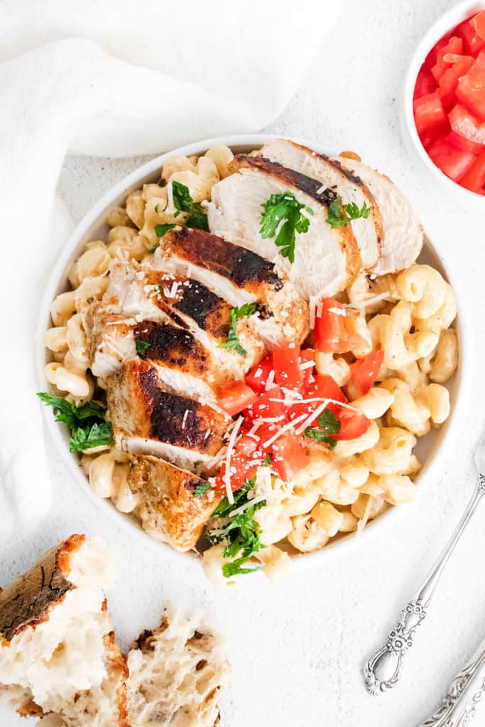 cajun chicken breasts sliced over alfredo pasta topped with parmesan and tomatoes