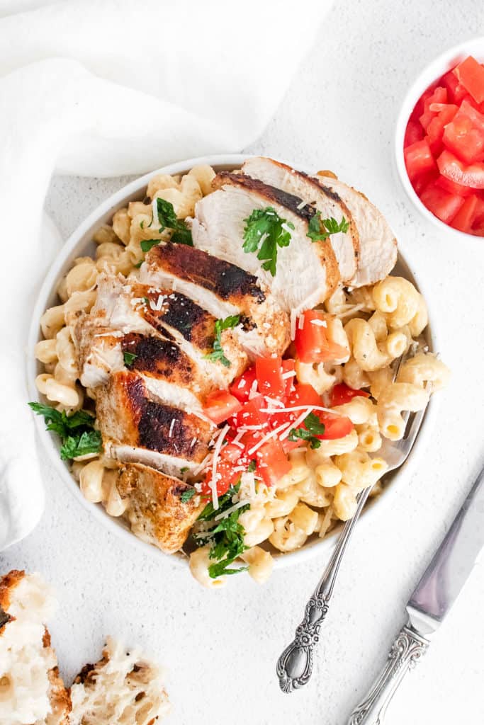 cajun chicken breasts sliced over alfredo pasta topped with parmesan and tomatoes