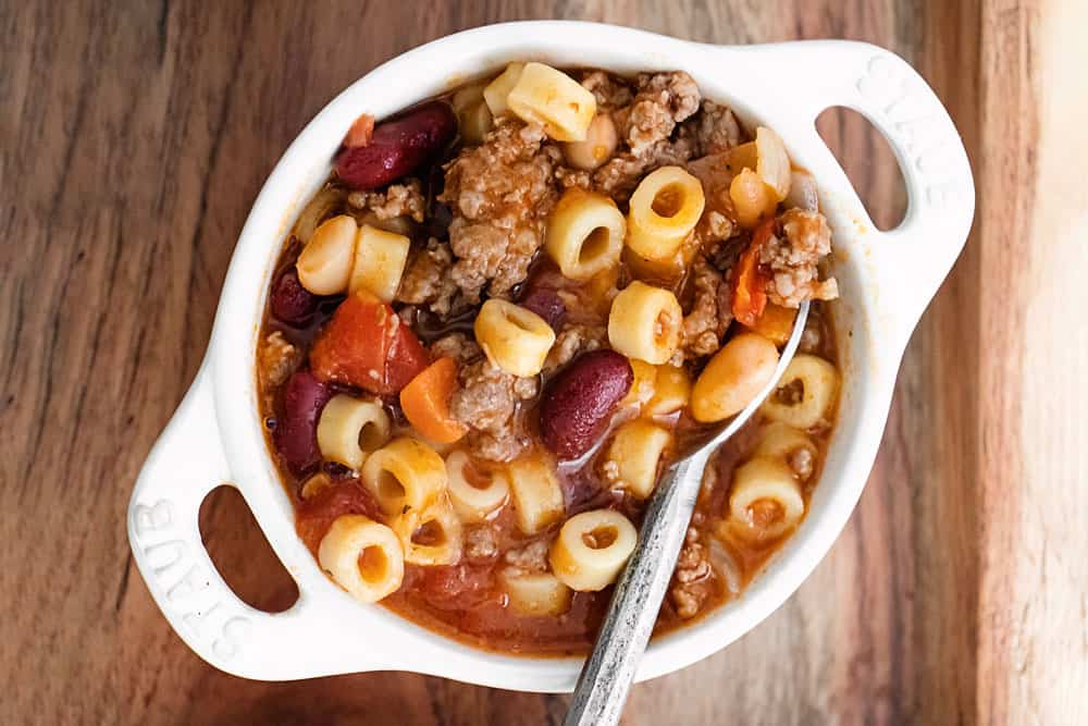 white bowl with pasta e fagioli soup and spoon