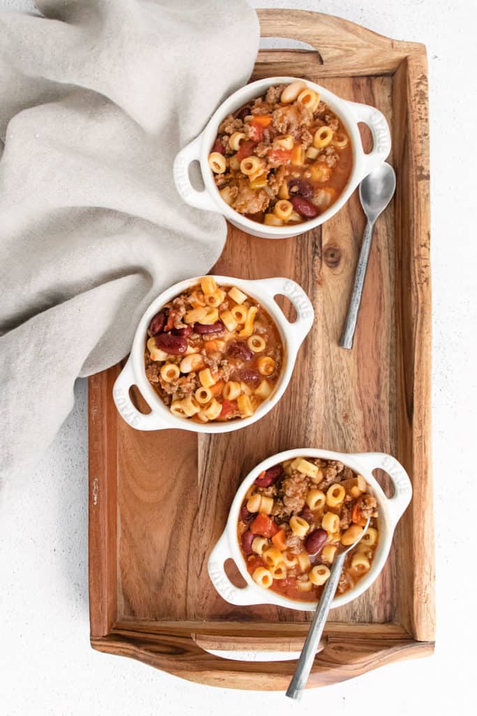 white bowls with pasta e fagioli soup on wood tray